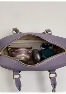 Internal view of purple pebble leather handbag showing capacity for phone and cosmetics