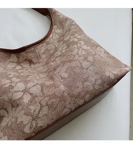 Detail of floral jacquard tote bag with premium brown leather handles and neat stitching