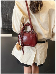 Close-up of wine red retro square bag with bear charm and adjustable shoulder strap
