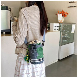 Outdoor crossbody water bottle bag with green plaid drawstring and floral charm