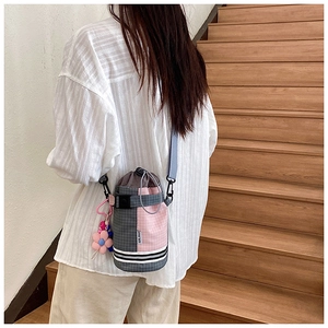 Detail of checkered drawstring bicycle bag with floral charm on wooden stairs