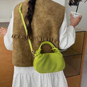 Lime green bucket bag with pleated texture shown in a casual lifestyle outfit