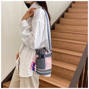 Close-up of pink and grey checkered crossbody bag with drawstring and star charm