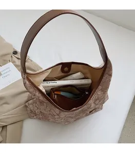 Spacious interior of brown leaf pattern tote bag with books and daily essentials
