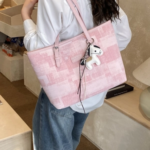 Detail of pink textured tote bag with horse charm and silver buckle adjustment