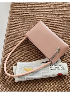 Detailed view of pink leather handbag with silver metallic chain and bead decor