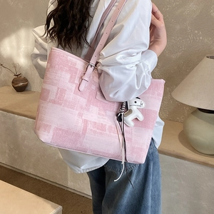 Pink printed tote bag with leather strap and white horse charm for daily commute