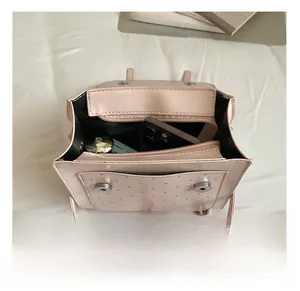 Internal view of a pink mini backpack showing pockets for phone and lipstick