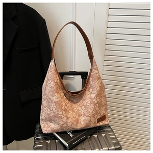 Detailed macro of floral hobo tote bag with brown leather strap on a silver suitcase