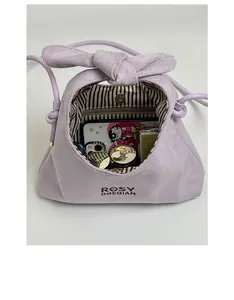 Detail of lavender suede mini handbag showing striped lining and magnetic closure