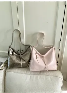 Detail view of large tote bags in silver and pink with pleated glossy faux leather texture