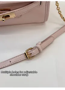 Detail of adjustable leather shoulder strap with golden buckle on a pink bucket bag