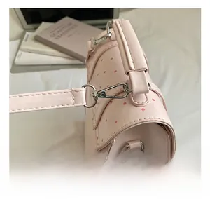 Detail of silver lobster clasp and D-ring on a pink polka dot mini leather backpack