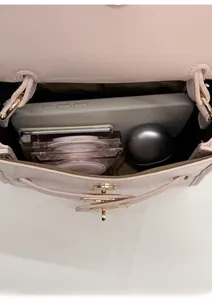 Detail view of pink leather bucket bag interior showing capacity for phone and makeup