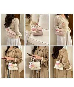 Detail of pink and white PU leather crossbody bags with gold locks and cute bunny charms