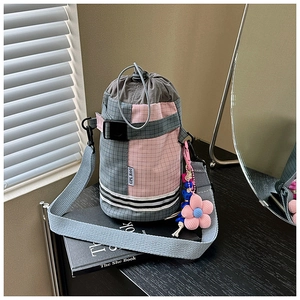 Detail of pink and grey checkered water bottle bag with drawstring and flower charm