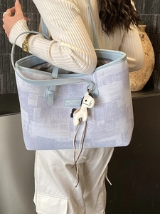 Women's light blue and white checkered large tote bag with horse pendant on shoulder