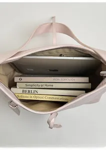 Spacious interior of pink oil wax leather tote bag holding a laptop and books