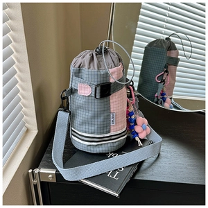 Detail of grey plaid and pink patchwork bike bag with drawstring and flower charm