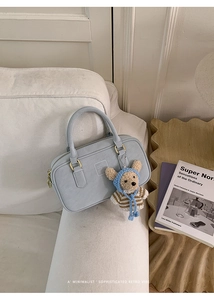 Élégant sac à main minimaliste bleu clair avec breloque ours dans un salon chic