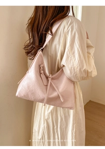 Detail of soft oil wax leather texture on large capacity light pink hobo shoulder bag