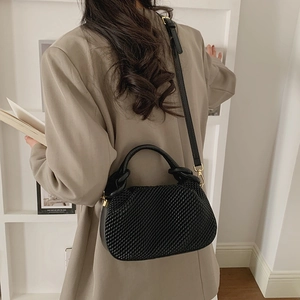 Detail of black woven texture on a stylish bucket bag with shoulder strap