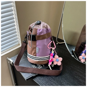 Detail of checkered nylon drawstring bike bag featuring purple and brown color blocking
