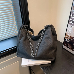 Détail du grand sac cabas en denim gris avec tissu texturé et bandoulières en chaîne