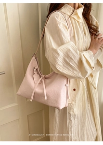 Detail view of pink oil wax leather shoulder bag with tassels and semi-circular moon shape