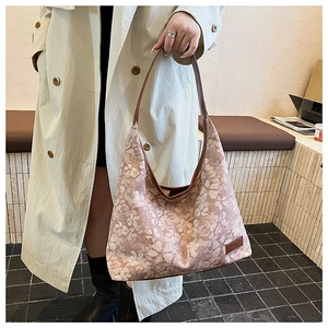 Detail of floral hobo tote bag showing large capacity and brown leather strap