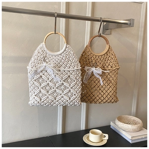 Detail of bohemian hollow woven beach bags with circular wooden handles and pearl bow decor