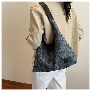 Detail of vintage floral tote bag with black leather strap and textured grey canvas fabric