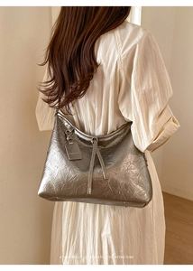 Close-up of silver hobo bag with vintage crinkle texture and hanging fashion tassel