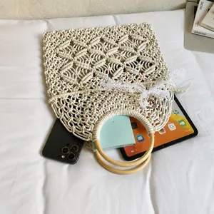 Detailed interior capacity of woven macrame bag with phone, tablet, and wood handles