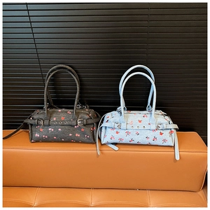Detailed shot of dark grey and light blue floral print handbags with metal buckle accents