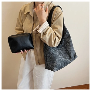 Detail view of charcoal floral canvas tote and black leather clutch bag set for women