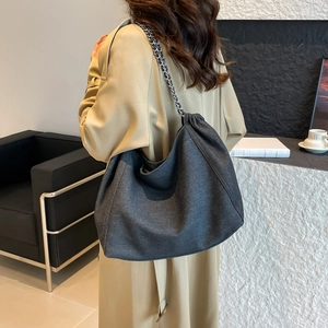 Détail du grand sac cabas en denim gris avec bandoulière chaîne argentée