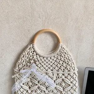 Detail of woven beach tote with circular wooden handle and lace ribbon accessory