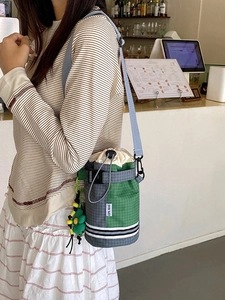 Outdoor drawstring water bottle bag in grey and green nylon with a blue shoulder strap