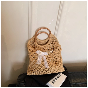 Détail du sac de plage tressé avec poignées en bois et nœud en dentelle délicate