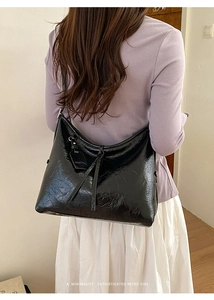 Detailed back view of a large black retro oil wax leather tote bag with tassel accents