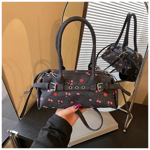 Detail of dark grey denim Boston bag featuring red rose print and silver metal buckles