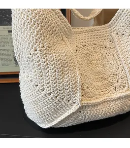 Détail macro du sac cabas en crochet blanc crème montrant la texture alvéolée tissée
