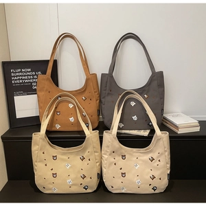 Close-up of canvas tote bags with cute cartoon bear and cat embroidery in four colors
