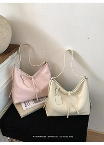 Detail of pink and beige large oil-wax leather tote bags with minimalist knot decoration