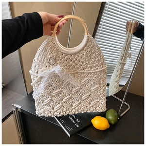 Détail du sac à main tissé en coton avec anses en bois et nœud en dentelle élégant