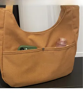 Close-up of durable canvas tote bag featuring a practical front pocket with metal snap