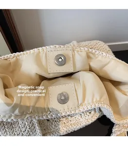 Détail du fermoir magnétique et des coutures sur un sac seau en maille de couleur beige