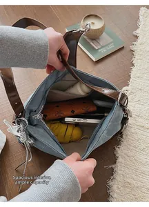 Spacious interior of blue denim shoulder bag showing storage for umbrella and wallet