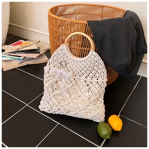 Detailed close-up of handmade woven tote bag with wooden handles and lace bow detail